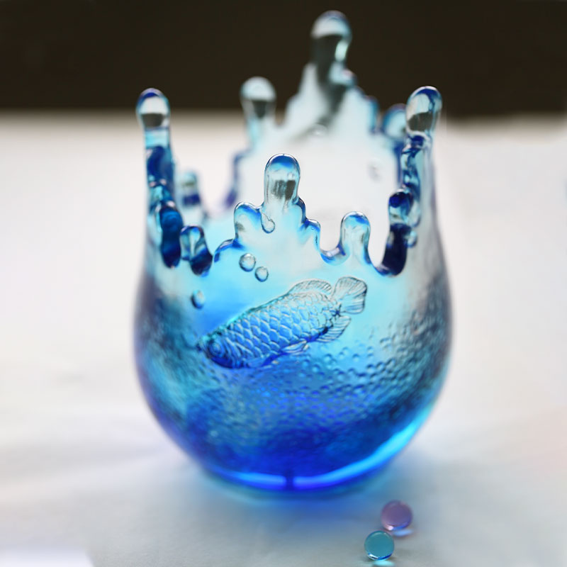 Blauwe glaswerkornamenten gegraveerd met vispatronen