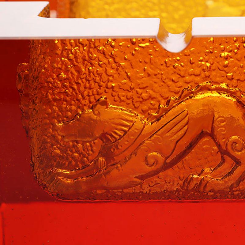 Asbak van rood glas met prachtige dierenpatronen in reliëf