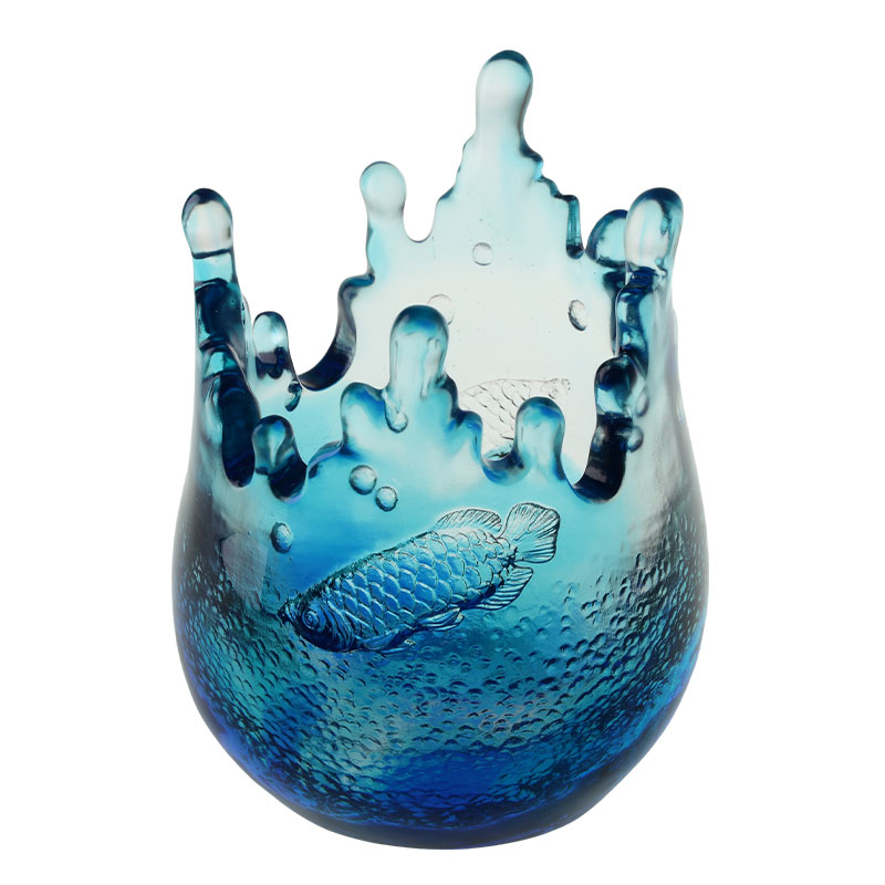 Blauwe glaswerkornamenten gegraveerd met vispatronen